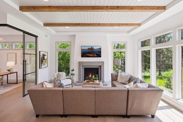 living room with wood ceiling, beamed ceiling, and light hardwood / wood-style flooring