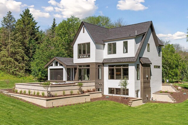 back of property with a lawn and a sunroom