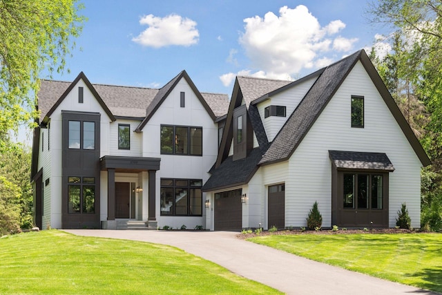 modern farmhouse featuring a garage and a front lawn