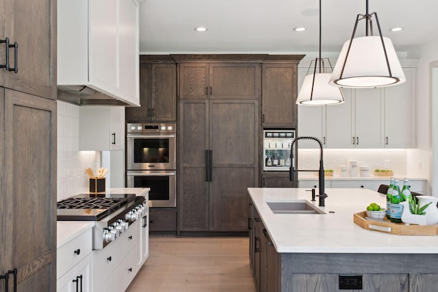 kitchen featuring hanging light fixtures, stainless steel appliances, and white cabinets