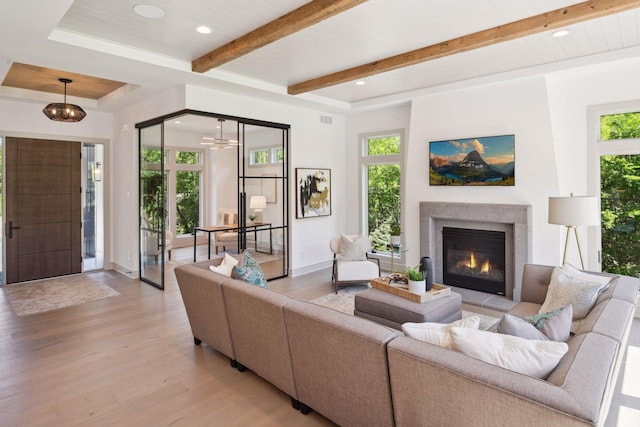 living room with light hardwood / wood-style floors and beamed ceiling