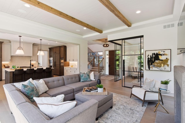 living room featuring light wood-type flooring and beam ceiling