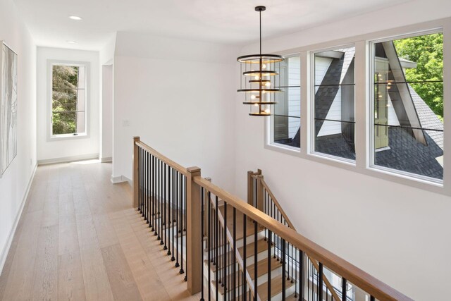 hallway featuring light wood-type flooring and a chandelier