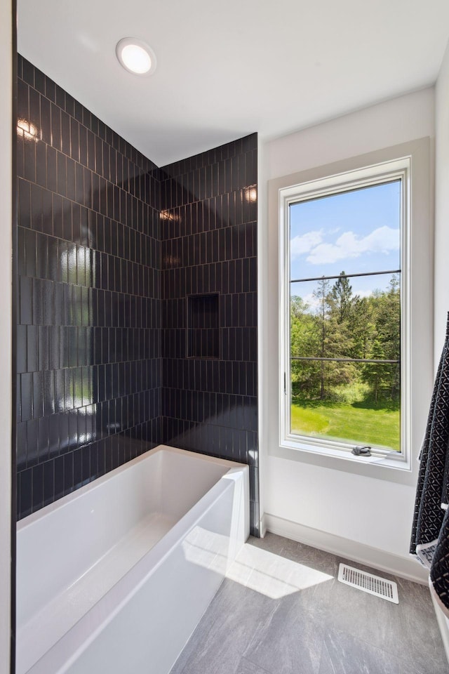 bathroom featuring a healthy amount of sunlight and shower / bathtub combination