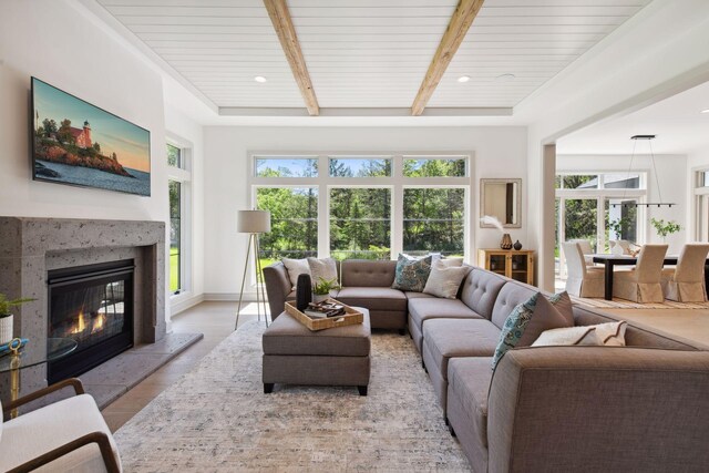 living room featuring wooden ceiling, a high end fireplace, and a healthy amount of sunlight