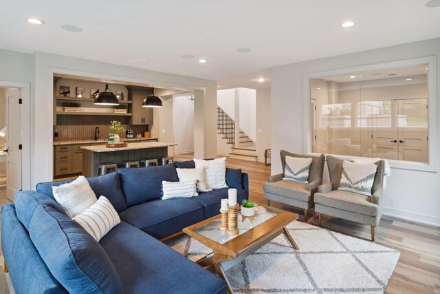 living room featuring sink and light hardwood / wood-style flooring