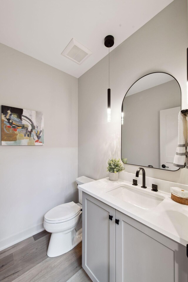 bathroom featuring vanity, toilet, and hardwood / wood-style floors