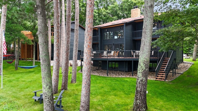 back of house with a wooden deck and a yard