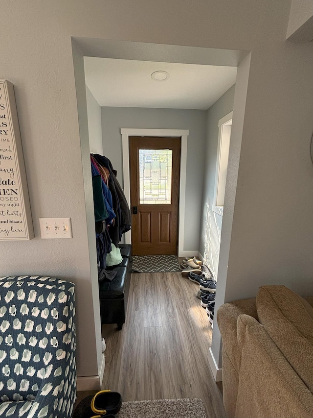 doorway featuring baseboards and wood finished floors