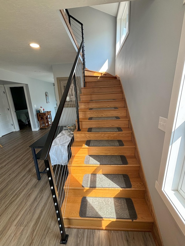 staircase with recessed lighting, baseboards, and wood finished floors