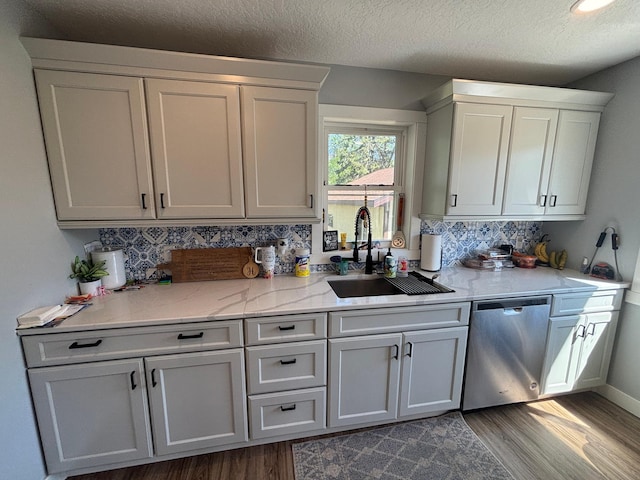 608 Granger Rd, Detroit Lakes, MN 56501 - kitchen with stainless steel dishwasher, a sink, dark wood finished floors, tasteful backsplash, and a textured ceiling