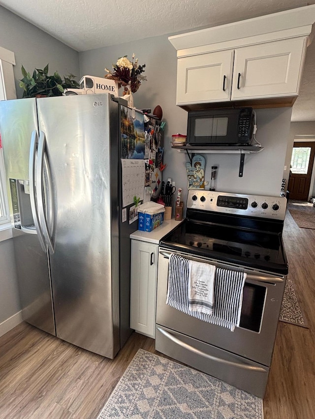 608 Granger Rd, Detroit Lakes, MN 56501 - kitchen featuring appliances with stainless steel finishes, light wood-style floors, white cabinetry, a textured ceiling, and light countertops