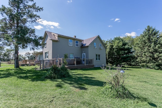 back of house featuring a deck and a lawn