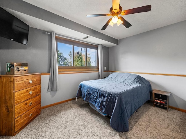 bedroom with a textured ceiling, light colored carpet, and ceiling fan