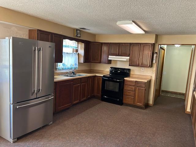 kitchen featuring sink, high end refrigerator, dark colored carpet, black range with electric stovetop, and a textured ceiling