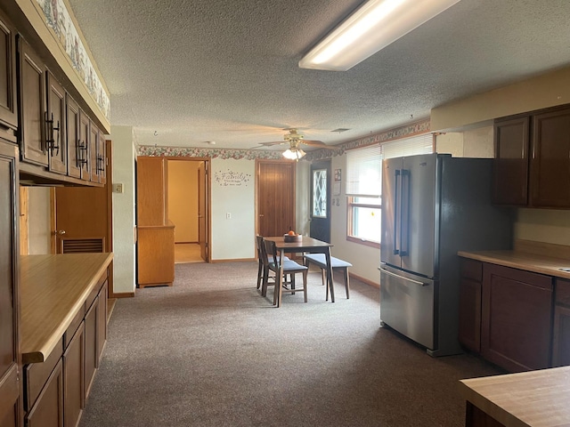 kitchen with stainless steel refrigerator, carpet floors, ceiling fan, dark brown cabinets, and a textured ceiling