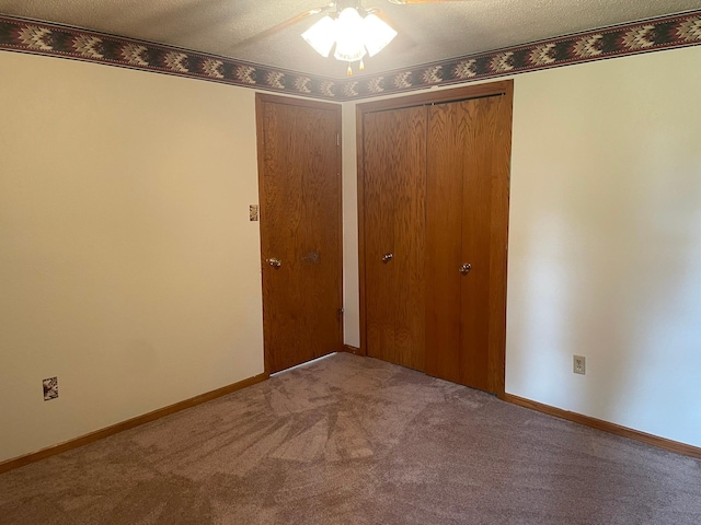 unfurnished bedroom with carpet, a textured ceiling, and a closet