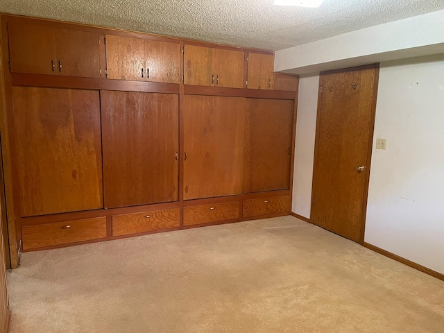 unfurnished bedroom featuring light colored carpet and a textured ceiling