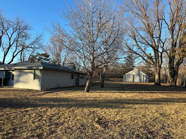 view of yard featuring a garage and an outdoor structure