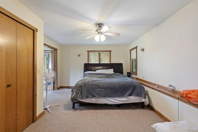 carpeted bedroom featuring a ceiling fan, a closet, and baseboards