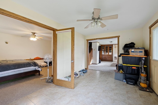 bedroom with a ceiling fan, french doors, and light colored carpet