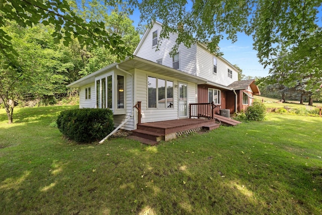 back of property with a yard, a deck, and central AC unit