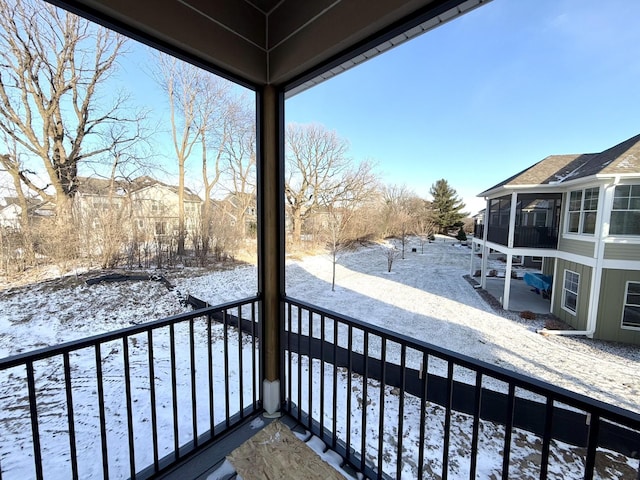 view of snow covered back of property