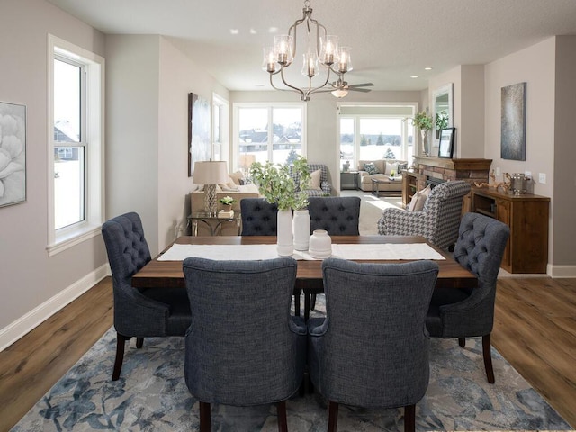 dining area featuring dark wood-type flooring and ceiling fan with notable chandelier