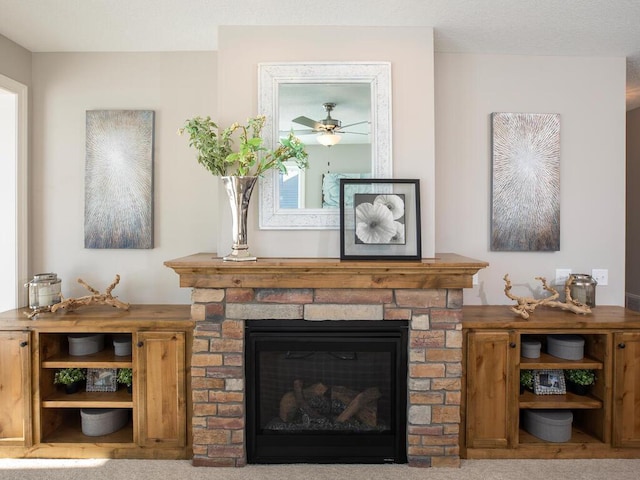 interior space with ceiling fan, a stone fireplace, and carpet floors