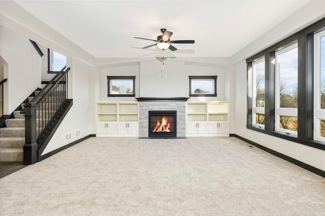 unfurnished living room with vaulted ceiling, a fireplace, carpet, built in features, and ceiling fan