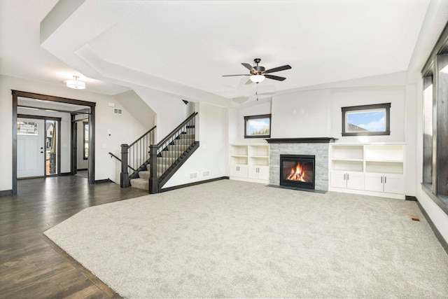 living room with built in shelves, ceiling fan, dark hardwood / wood-style floors, and a fireplace