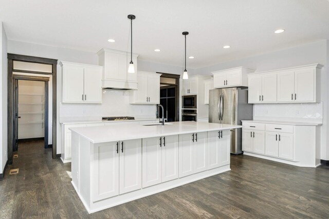 kitchen with dark wood-type flooring, white cabinets, stainless steel appliances, and a center island with sink