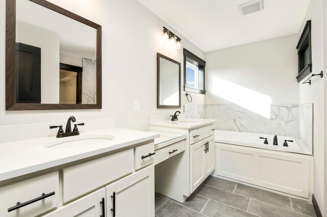 bathroom with vanity, a bathing tub, and tile patterned floors