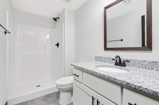 bathroom featuring vanity, toilet, walk in shower, and tile patterned floors