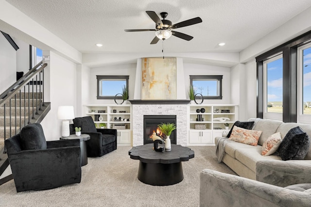 1105 136th St E, Rosemount, MN 55068 - carpeted living room featuring a fireplace, a textured ceiling, a ceiling fan, recessed lighting, and stairs