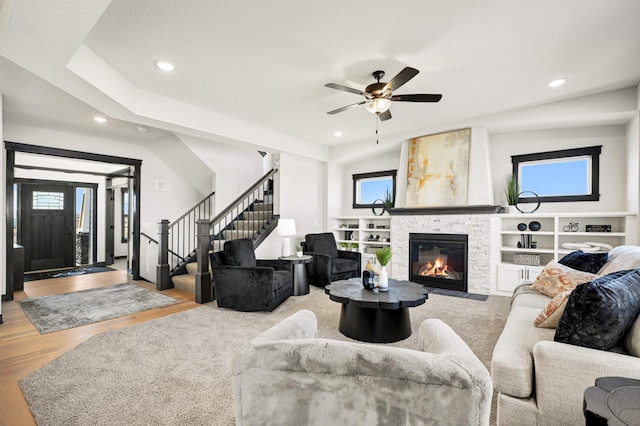 1105 136th St E, Rosemount, MN 55068 - living room with a stone fireplace, recessed lighting, ceiling fan, stairway, and wood finished floors