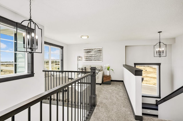 1105 136th St E, Rosemount, MN 55068 - corridor featuring a chandelier, light carpet, an upstairs landing, baseboards, and a textured ceiling