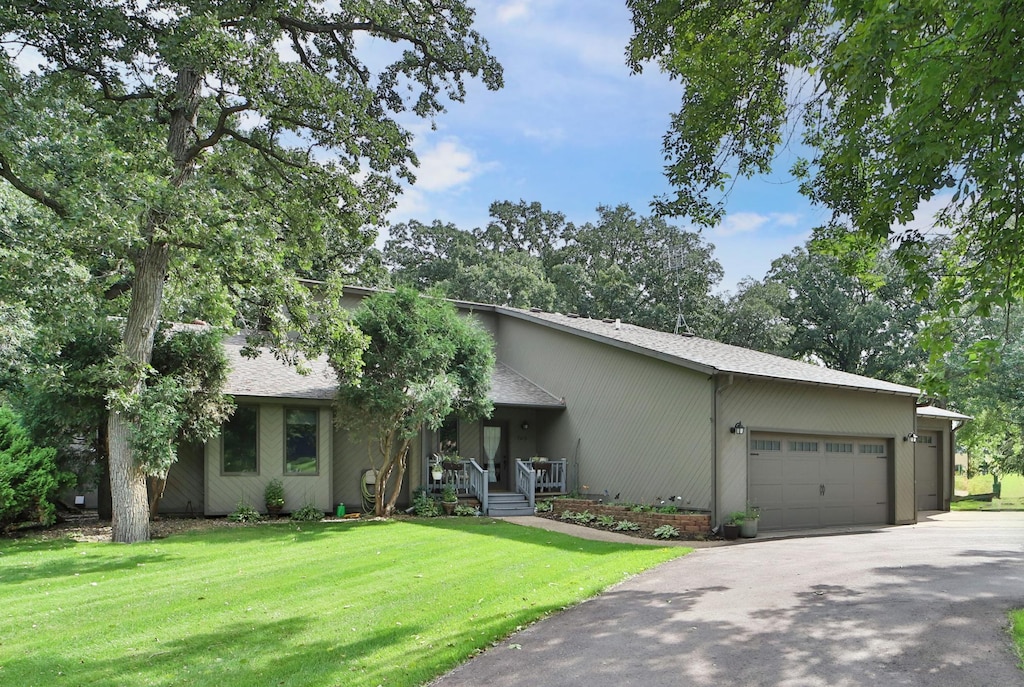 ranch-style home featuring a front yard, a garage, and a porch