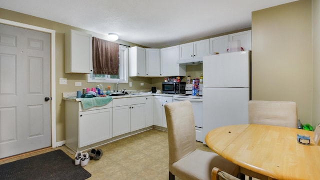 kitchen featuring white appliances, white cabinetry, and sink