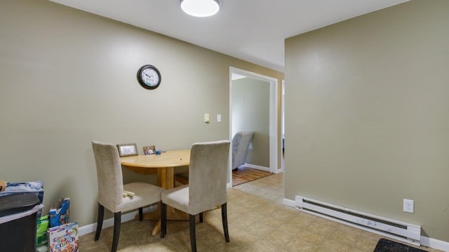 dining room with a baseboard heating unit and light wood-type flooring