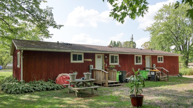 back of house with a wooden deck and a lawn