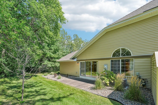 back of house with a lawn and a patio