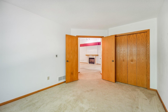 unfurnished bedroom with carpet flooring, a textured ceiling, and a closet