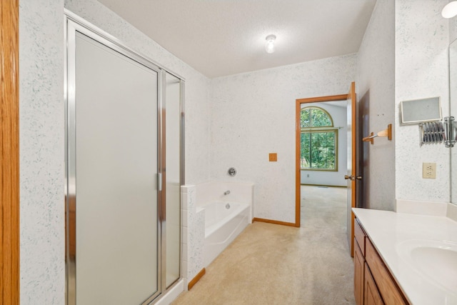 bathroom with a textured ceiling, vanity, and independent shower and bath