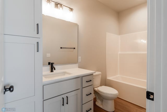 bathroom with hardwood / wood-style floors, vanity, and toilet