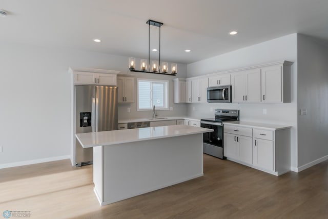 kitchen with white cabinetry, sink, a center island, and appliances with stainless steel finishes