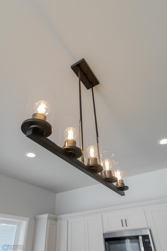 details with a chandelier and white cabinetry