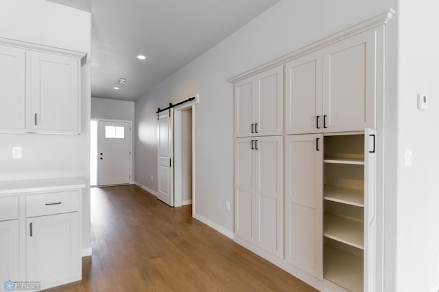 hallway featuring a barn door and light wood-type flooring