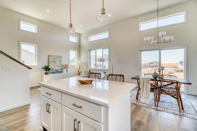 kitchen with white cabinets, a center island, plenty of natural light, and light hardwood / wood-style floors