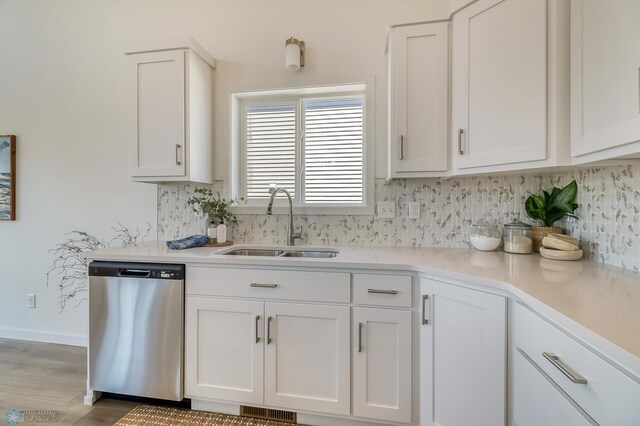 kitchen with dishwasher, white cabinetry, and sink